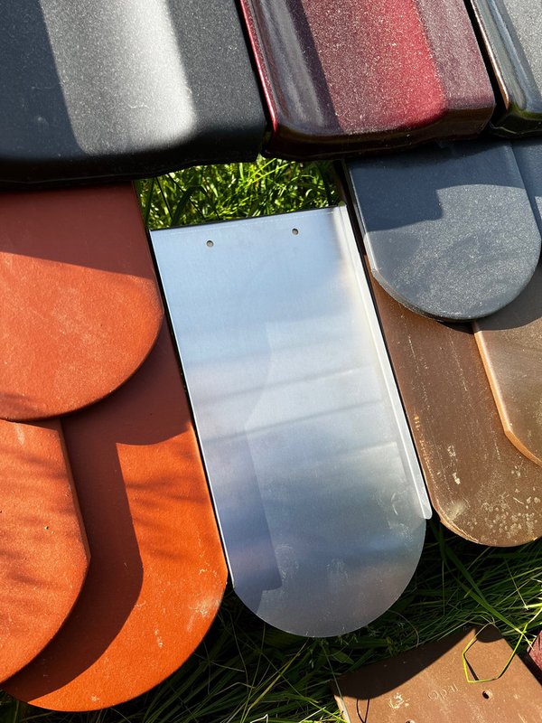 Montage-Solarziegel fĂŒr PV-Dachziegel Typ Biberschwanz: Aluminium-Ersatzziegel zwischen farbigen Biberschwanz-Dachziegeln zur sicheren Photovoltaik-Montage.