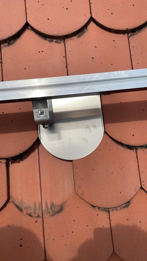 PV-Dachziegel Typ Biberschwanz im Detail: montierte Aluminium-PV-Halterung auf roten Biberschwanz-Dachziegeln, geeignet zur sicheren Befestigung von Photovoltaik-Modulen.
